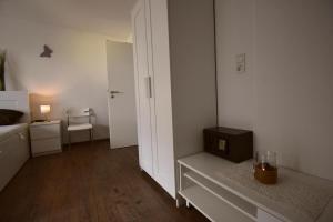 ドルヌムにあるFerienwohnung Border Collieの小さなお部屋で、ベッド1台、テーブル(時計付)が備わります。