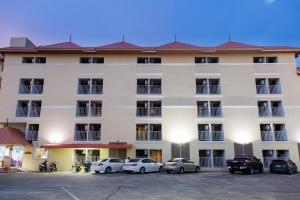 a large white building with cars parked in a parking lot at Eco Hostel Hua Hin in Hua Hin +44 photos
