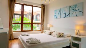Un dormitorio con una cama blanca y una ventana grande. en Апартаменти Бяла Клиф - Byala Cliff Apartments, en Byala 185 fotos más