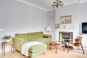 カーディフにあるCharming Elegance at The Pontcanna Pearl - Prime Location with Comfort and Styleのリビングルーム(緑のソファ、暖炉付)