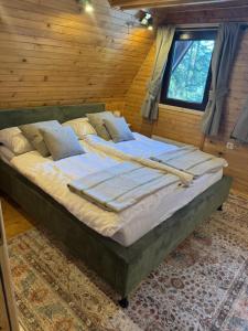 a large bed in a room with wooden walls at Mountain Mia in Šišava
