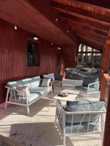 a living room with couches and chairs on a patio at Mountain Mia in Šišava +15 photos