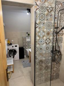 a bathroom with a shower with a tile wall at Mountain Mia in Šišava