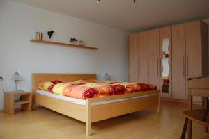 a bedroom with a bed and wooden cabinets at Ferienwohnung Matzenmiller in Wilhelmsdorf