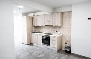 ナポリにあるEcumano Spaceの白いキャビネットとコンロ付きオーブンを備えたキッチン