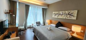 a hotel room with a bed and a television at COZY SUPER KING BED STUDIO walking to PETRONAS KLCC by Zen Glo in Kuala Lumpur +10 photos
