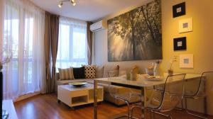 una sala de estar con una mesa y un sofá en Апартаменти Бяла Клиф - Byala Cliff Apartments, en Byala