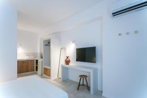 une chambre avec un lit et un bureau avec une télévision dans l'établissement Paris Studios & Apartment, à Agia Paraskevi