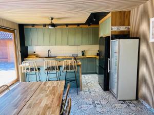 a kitchen with a wooden table and a refrigerator at Leśne Zacisze Kawice in Kawice