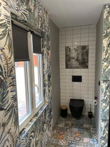 a bathroom with a black toilet and a window at Leśne Zacisze Kawice in Kawice +34 photos