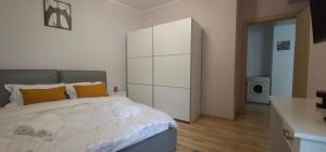 a bedroom with a large white bed with orange pillows at Sinaia Mountain View Residence Belleview in Sinaia +28 photos