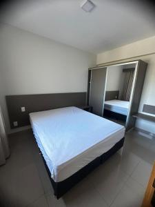 a bedroom with a large bed and a mirror at APTO 115 Park Veredas - Vista Piscinas - Acesso ao Rio quente - Espetacular in Rio Quente