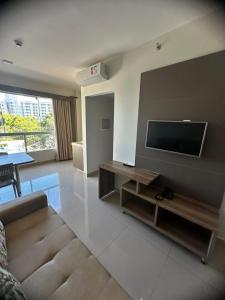 a living room with a couch and a flat screen tv at APTO 115 Park Veredas - Vista Piscinas - Acesso ao Rio quente - Espetacular in Rio Quente