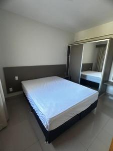 a large bed in a room with a mirror at APTO 115 Park Veredas - Vista Piscinas - Acesso ao Rio quente - Espetacular in Rio Quente +65 photos
