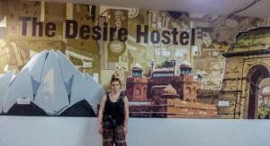 a woman standing in front of a wall with a mural at The Desire Hostel in New Delhi