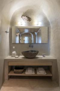 a bathroom with a sink and a mirror at Porto Fira Suites in Fira +127 photos
