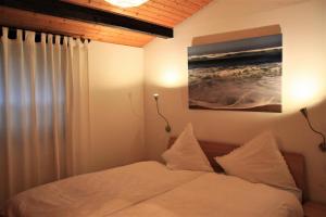 a bedroom with a bed and a painting on the wall at Ferienhaus Schöps in Burhave