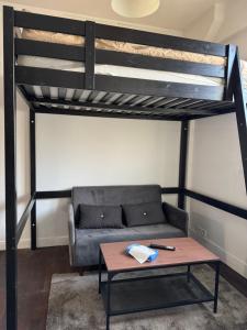 a living room with a couch and a loft bed at Studio Stade de France RER B in Aubervilliers