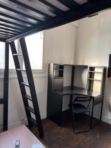 a loft bed with a desk and a ladder at Studio Stade de France RER B in Aubervilliers