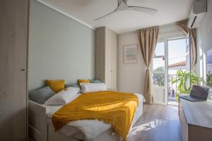 a bedroom with a bed with a yellow blanket on it at Estudio San Juan in Benalmádena
