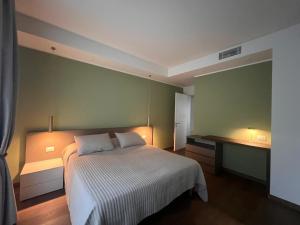 a bedroom with a white bed and a green wall at Casa Anna Venezia in Meolo