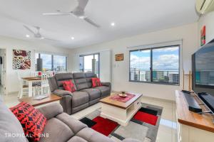 a living room with a couch and a table at Penthouse Vibes Amazing Views From Top Floor in Darwin