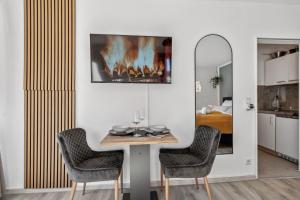a dining room with a table with chairs and a fireplace at Hellohome I Gemütliches City Studio mit großer Dachterrasse & Parkplatz in Braunschweig