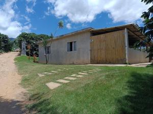 a small building with a grass yard in front of it at Recanto do Sossego in Alto Caparao