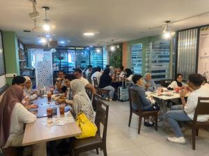 a group of people sitting at tables in a restaurant at Hotel La ISRA at Kuala Lumpur in Kuala Lumpur