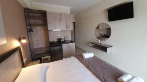 a small room with a bed and a kitchen at Calypso Beach Hotel in Paralia Katerinis
