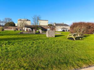 a picnic table in a field with a building in the background at mitchelstown castle chalet in Mitchelstown