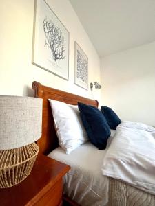 a bedroom with a bed with blue and white pillows at Villa Agapella 250m from the beach - Agapella Apartamemty in Sopot
