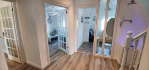 a hallway with an open door to a room with wooden floors at Stunning Harbour View Beachfront Apartment Parking in Rhos-on-Sea +47 photos