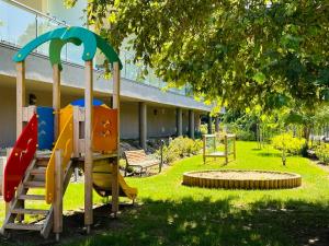ein Spielplatz mit Rutsche im Hof in der Unterkunft Casa Romana 3 Siófok apartman in Siófok + 16 Fotos