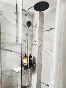 a shower in a bathroom with white marble at Sea and Cinema,two bedrooms apartment in Loutraki +24 photos