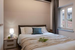 萨维利亚诺Due archi的一间卧室配有一张带蓝色枕头的床和窗户