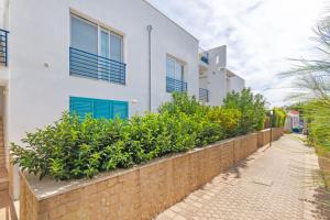 a building with blue windows and a brick wall at Beach Life Apartment In Boncore in Torre Lapillo