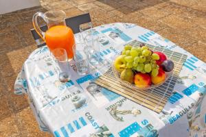 a table with a bowl of fruit and a pitcher of orange juice at Beach Life Apartment In Boncore in Torre Lapillo