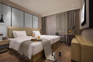 Giường trong phòng chung tại Starry Sky Garden Hotel Wuhan Hankou Railway Station Zhuyeshan Subway Station Branch