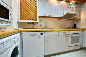 une cuisine avec des armoires blanches et une laveuse et une sécheuse dans l'établissement Dos Torres Santa Isabel - Parking gratis, à Saragosse