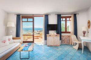 salon z kanapą i stołem w obiekcie Hotel Resort & Spa Baia Caddinas w mieście Golfo Aranci