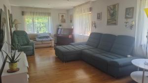 a living room with blue couches and a piano at Sweet Home in Koknese