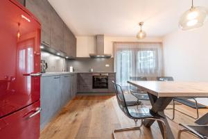 kuchnia ze stołem i czerwoną lodówką w obiekcie Panoramic Apartment 24 w mieście Ortisei
