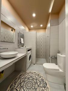 a bathroom with a toilet sink and a washing machine at Park Azure 0568 in Baku