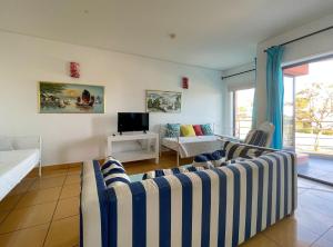a living room with a couch and a tv at Apartamentos da Orada T1-F124 Marina de Albufeira in Páteo