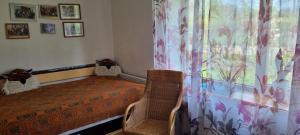 a bedroom with a bed and a window and a chair at Sweet Home in Koknese