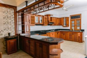 a kitchen with wooden cabinets and a black counter top at Maxxas hut in Boralesgamuwa