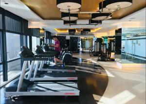 a woman exercising on a treadmill in a gym at Gramercy Residences Cozy 1BR Suite with 600mbps & Free amenities City view in Manila