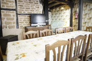 a dining room with a table and chairs and a tv at La Platería I in Mambrilla de Castrejón