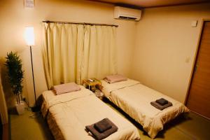 Postel nebo postele na pokoji v ubytování 桜の山荘